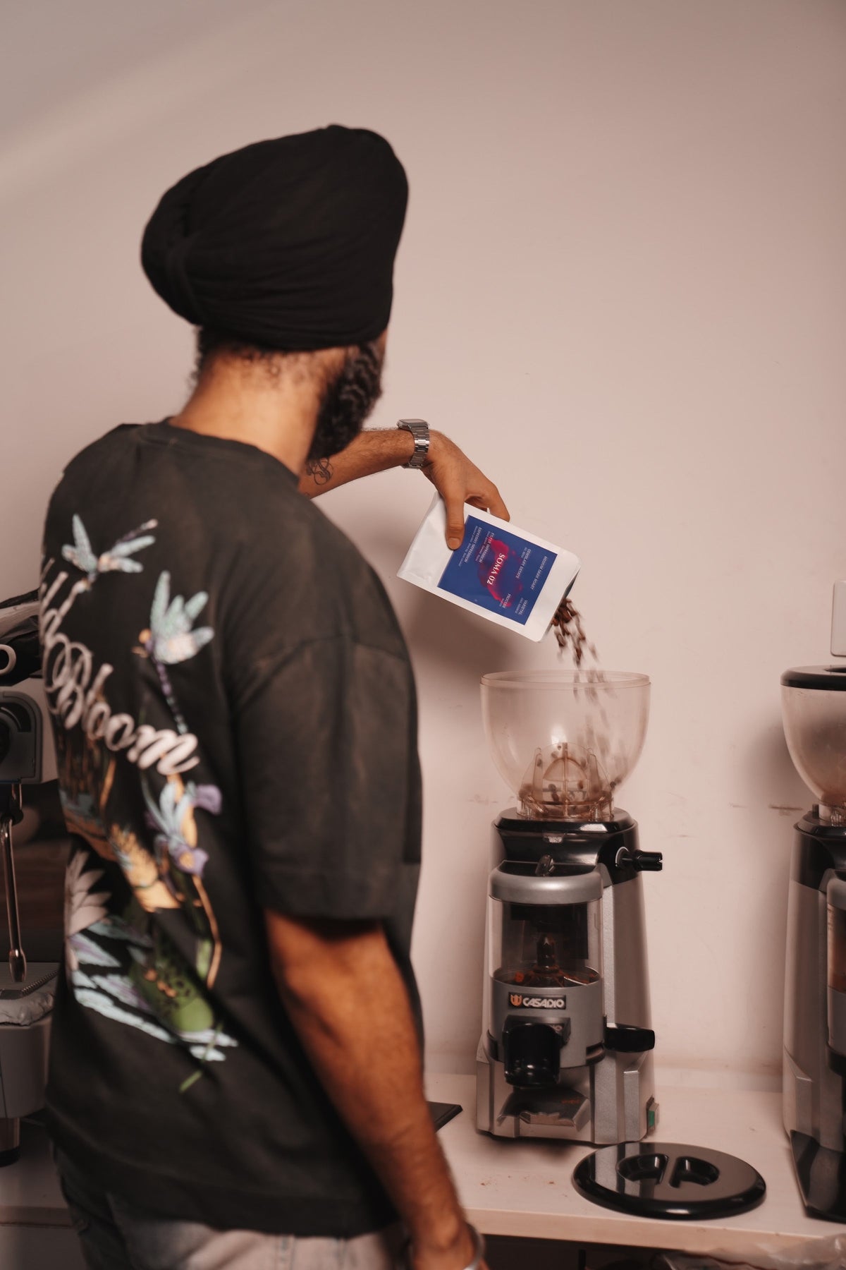 Pouring green coffee into the roaster hopper at BROOT, New Delhi