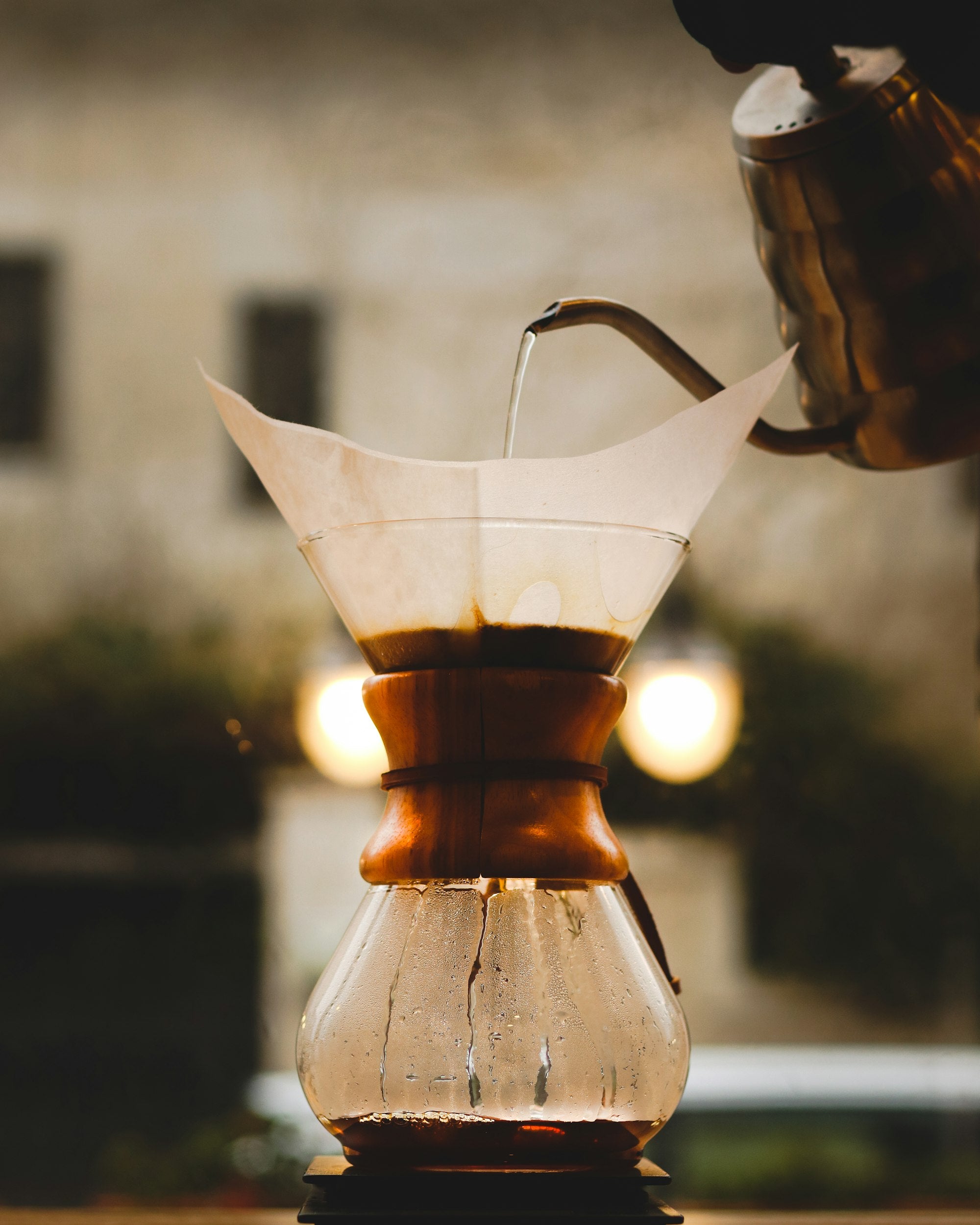 Water being poured slowly through a paper filter of coffee