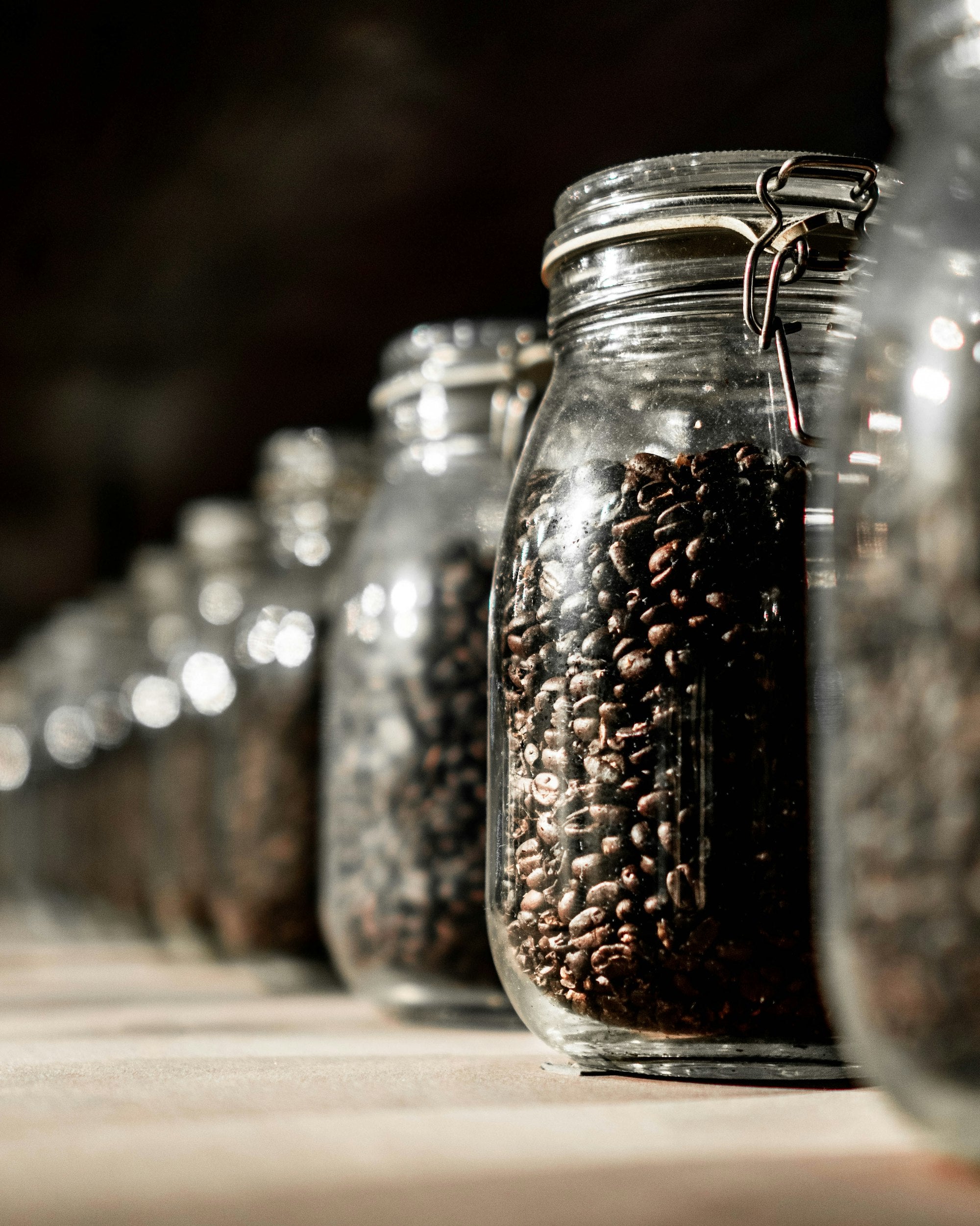 Sealed glass jars holding roasted coffee beans