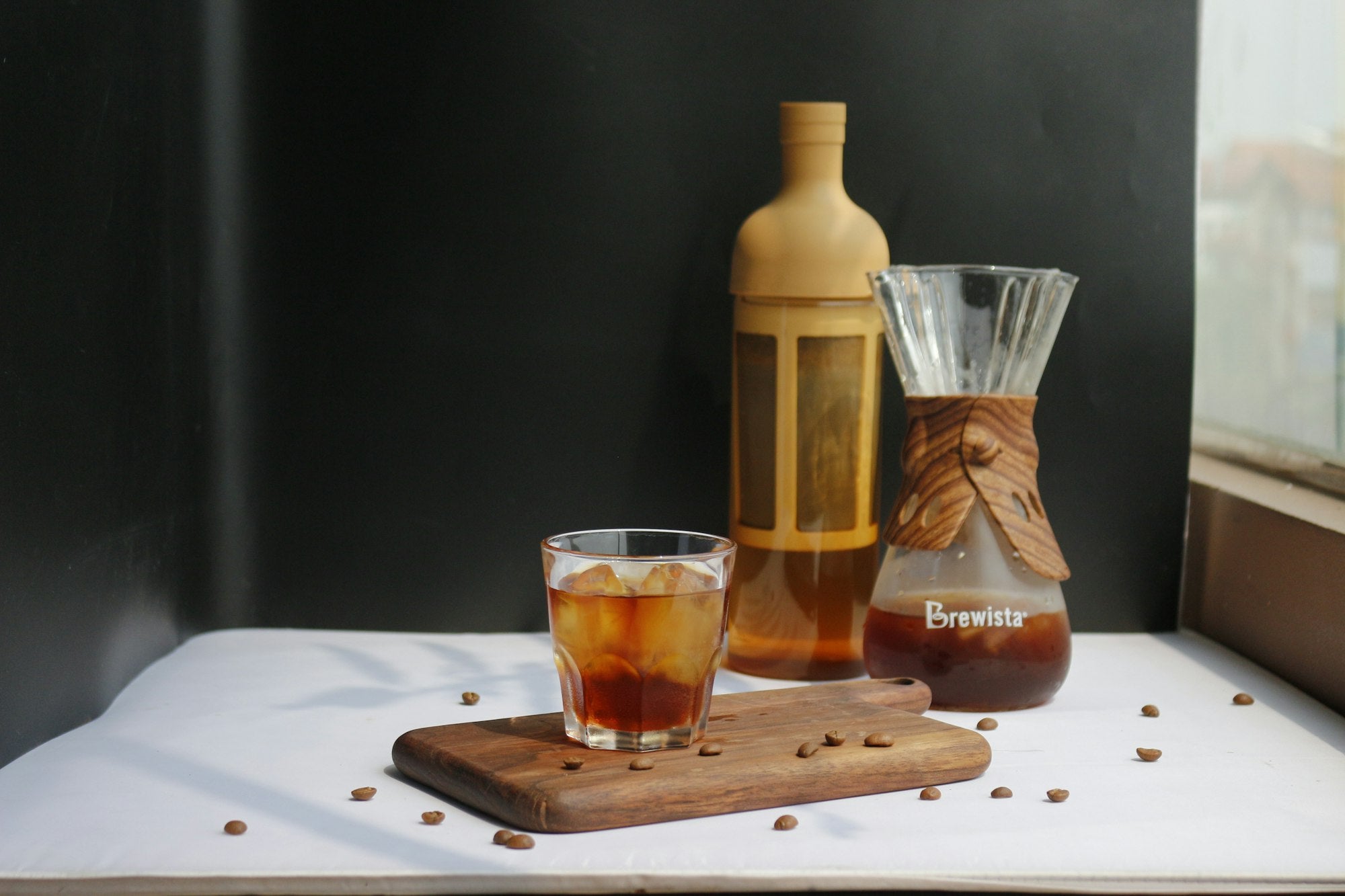 A bottle of cold brew concentrate with glasses of iced coffee