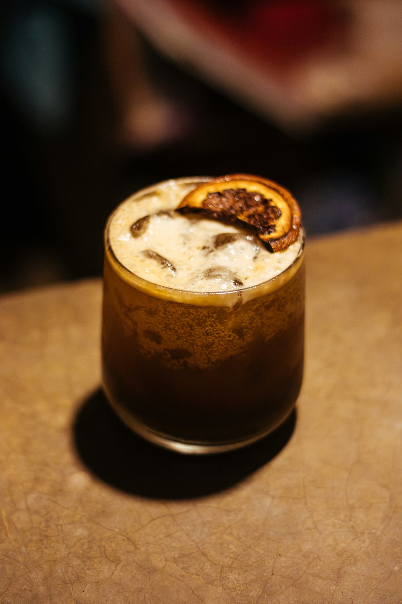 A cold brew tonic over ice with a slice of orange