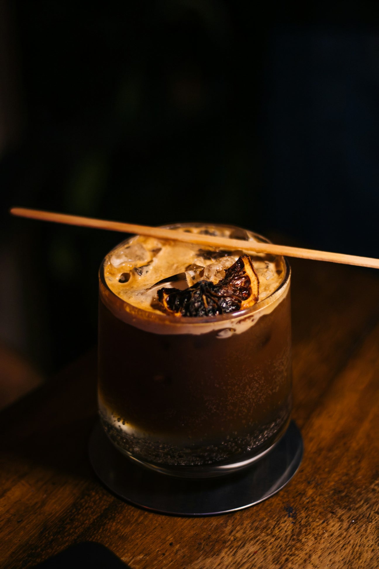 An espresso tonic layered over ice in a short glass