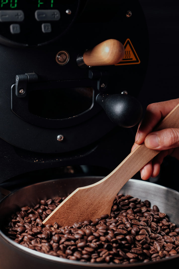 THE STANDARD subscription, a hand scooping roasted beans at BROOT's New Delhi roastery